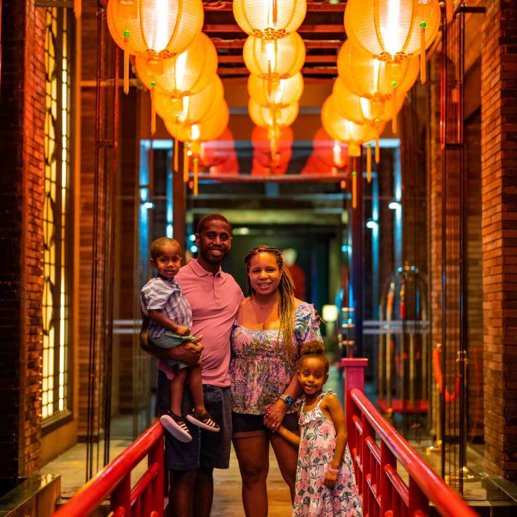 Family posed on a indoor bridge with laterns over their heads in Bangkok's Chinatown