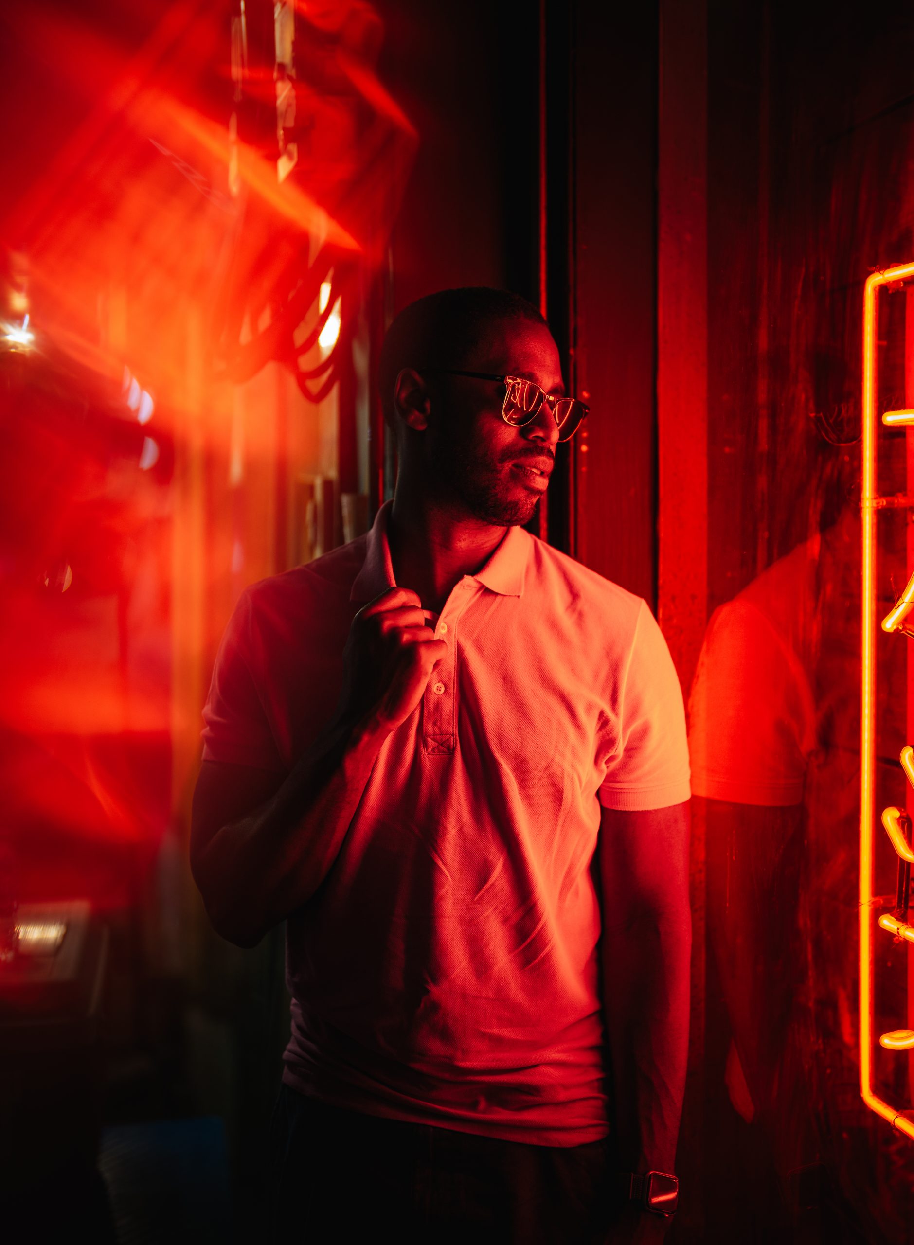 Image of player 2 looking off into the distance, illuminated by red signage from a sore